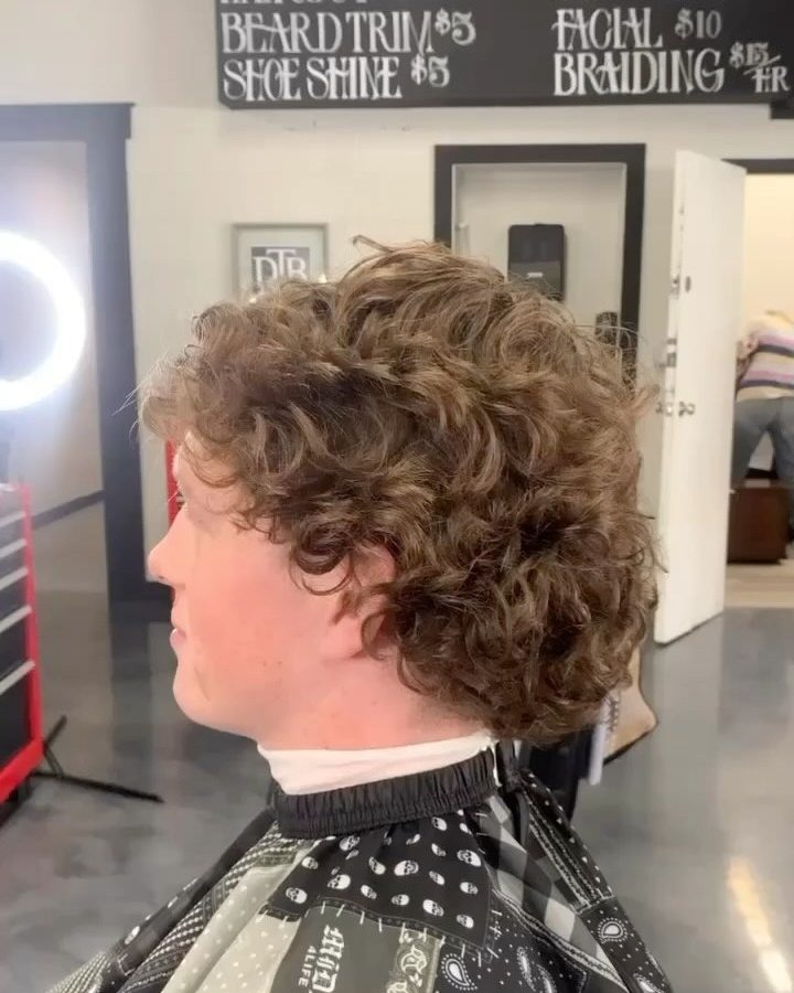 Side profile of a client with a curly top and tapered sides