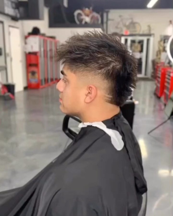 Side profile of a spiky mullet with a burst fade around the ear